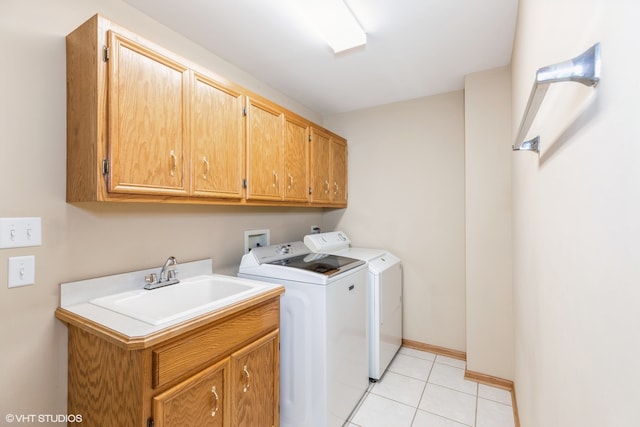 laundry area with washing machine and dryer, cabinets, light tile patterned floors, and sink