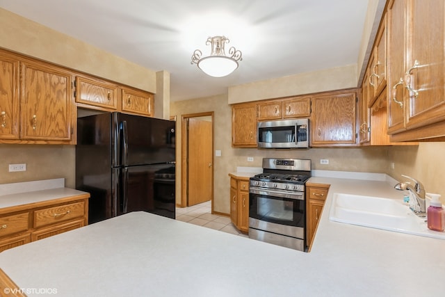 kitchen with light tile patterned floors, stainless steel appliances, and sink