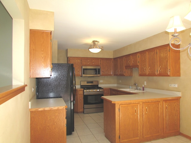 kitchen with light tile patterned floors, sink, appliances with stainless steel finishes, and kitchen peninsula