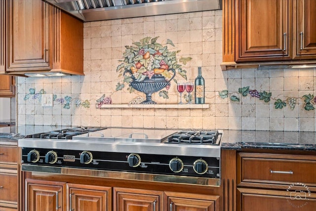 kitchen with decorative backsplash, stainless steel gas cooktop, dark stone counters, and range hood