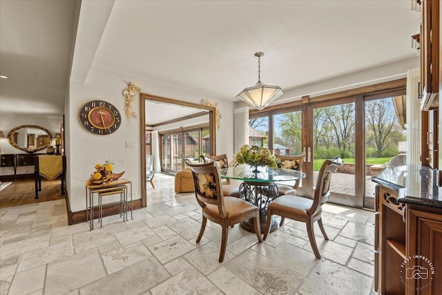 dining room with stone tile floors and baseboards