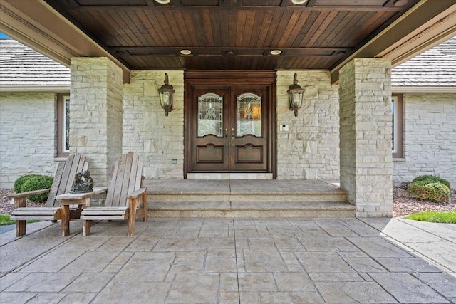 property entrance featuring covered porch and french doors