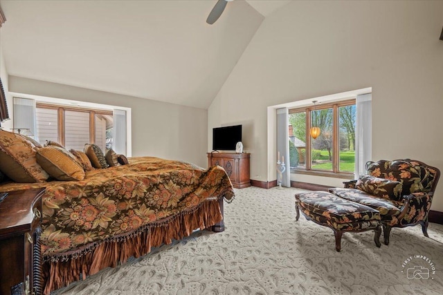 carpeted bedroom with high vaulted ceiling, a ceiling fan, and baseboards