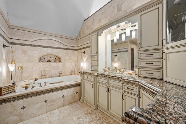 full bathroom featuring lofted ceiling, a garden tub, tile walls, and vanity