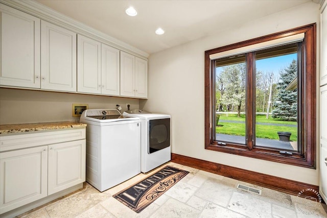 clothes washing area featuring cabinet space, baseboards, stone tile flooring, washing machine and dryer, and recessed lighting