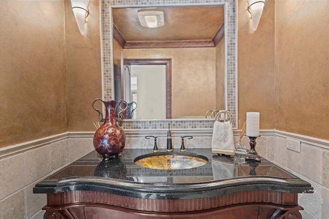 bathroom featuring ornamental molding, wainscoting, and vanity