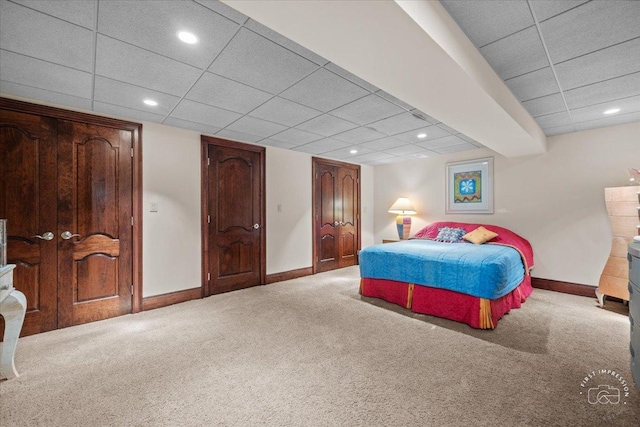 carpeted bedroom featuring recessed lighting, a paneled ceiling, and baseboards