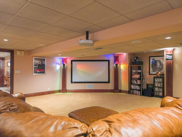 carpeted home theater room featuring visible vents, baseboards, and a drop ceiling