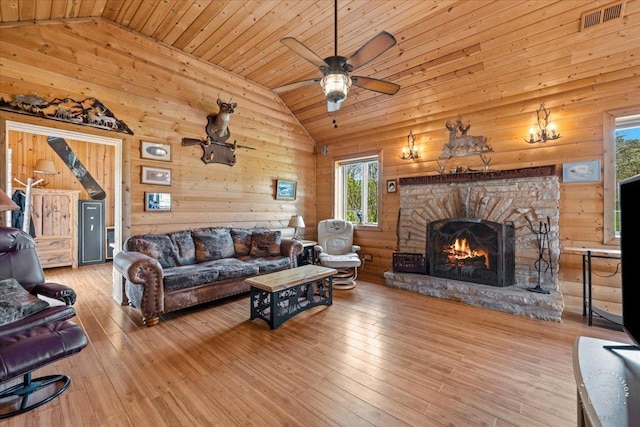 living area with high vaulted ceiling, wood ceiling, a stone fireplace, and hardwood / wood-style flooring