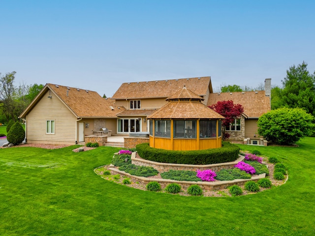 rear view of property with a yard and a gazebo