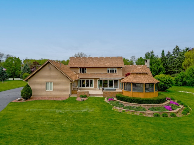 view of front of home featuring a sunroom and a front yard