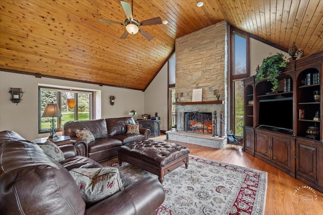 living room featuring wooden ceiling, light wood-style flooring, a fireplace, and high vaulted ceiling