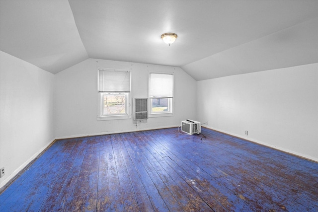 bonus room featuring a wall unit AC, heating unit, hardwood / wood-style floors, and lofted ceiling