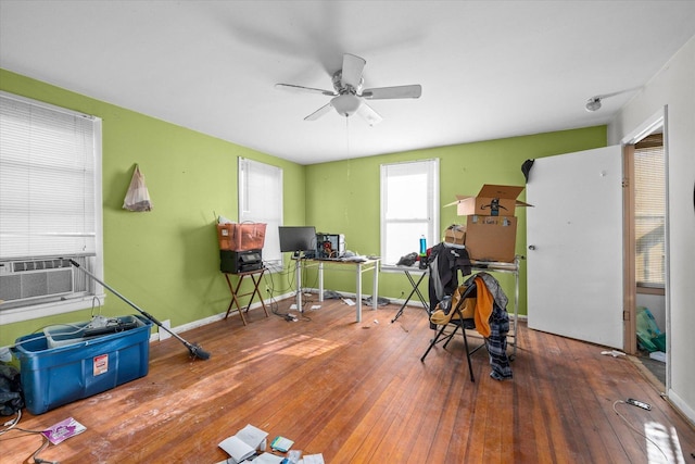 interior space with wood-type flooring, ceiling fan, and cooling unit