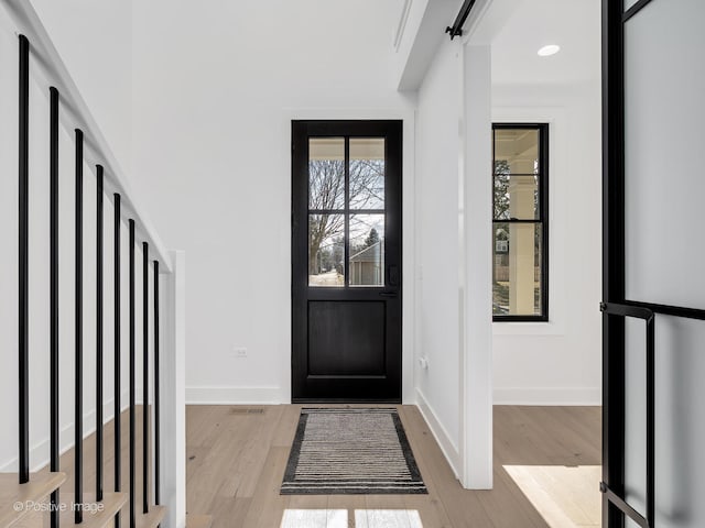 entrance foyer featuring light wood-type flooring and a barn door