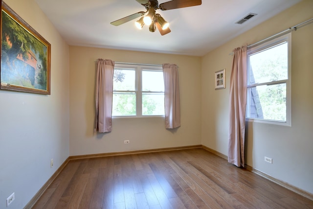 spare room with light hardwood / wood-style floors, ceiling fan, and a wealth of natural light