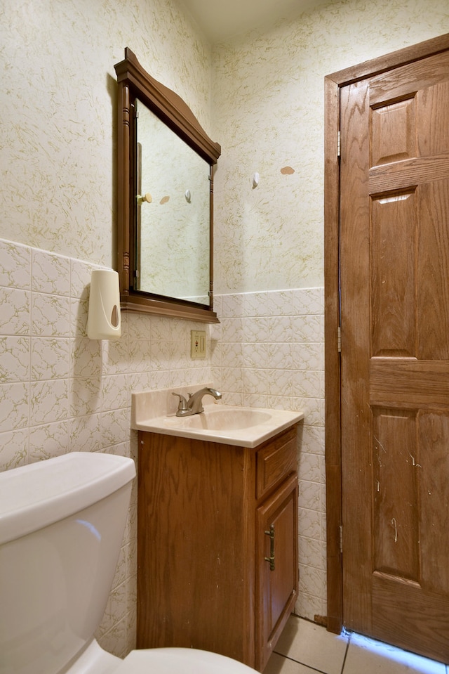 bathroom featuring vanity, tile walls, and toilet