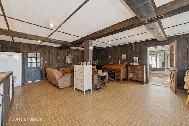 living area with beam ceiling, wooden walls, and parquet floors