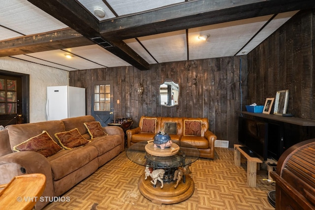 living room featuring visible vents, beam ceiling, and wood walls