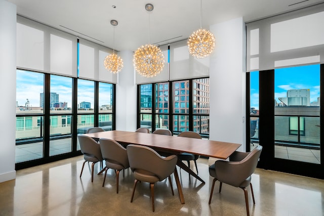 dining area with an inviting chandelier and a towering ceiling