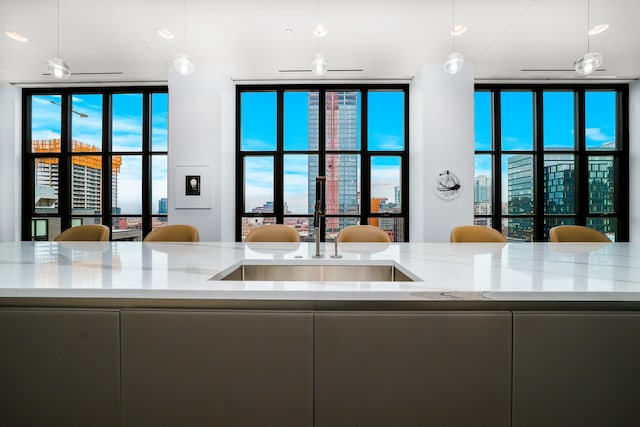 kitchen featuring light stone countertops and hanging light fixtures