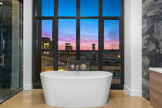 bathroom with concrete floors and a tub