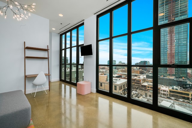 interior space featuring a notable chandelier, a towering ceiling, and a wall of windows