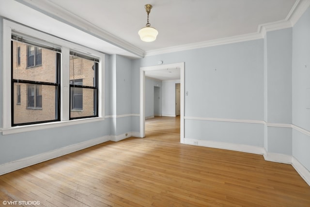 spare room featuring light wood-type flooring and crown molding