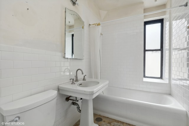 bathroom with tile walls, toilet, and shower / tub combo with curtain