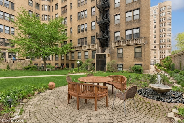 view of home's community with a lawn and a patio area