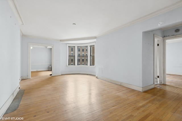 empty room with light wood-type flooring and ornamental molding