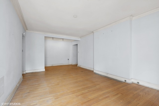 unfurnished room featuring light wood-type flooring and crown molding