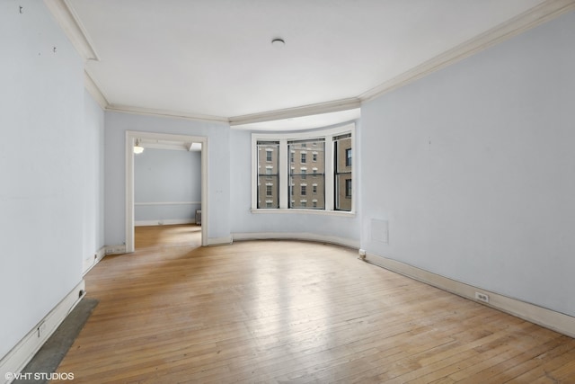 unfurnished room with light hardwood / wood-style floors and crown molding