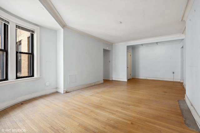 spare room with light hardwood / wood-style flooring and crown molding