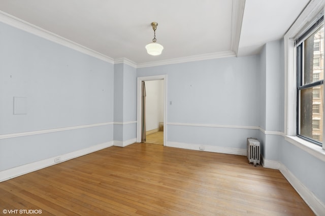 unfurnished room with ornamental molding, radiator, and light hardwood / wood-style flooring