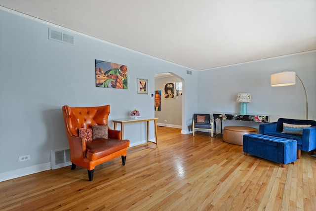 sitting room featuring crown molding and light hardwood / wood-style flooring