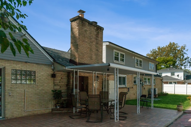 rear view of house with a lawn, a patio area, and central air condition unit