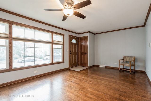 entryway featuring dark wood-type flooring, crown molding, and ceiling fan