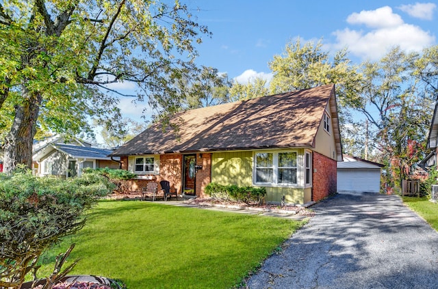 view of front of home with a front yard, an outbuilding, and a garage