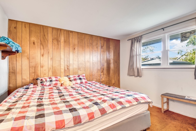 carpeted bedroom with wood walls