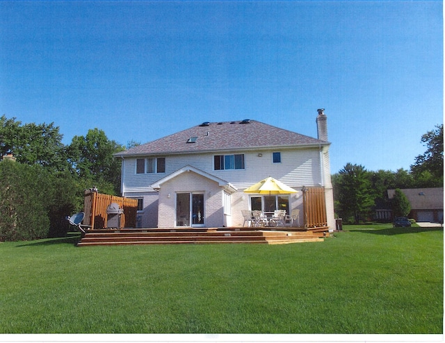 rear view of property featuring a yard and a wooden deck