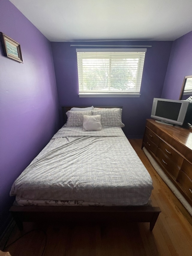 bedroom with hardwood / wood-style floors and multiple windows