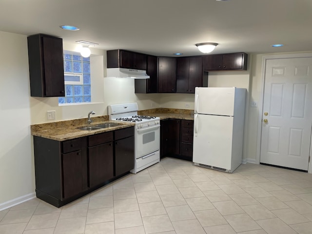 kitchen featuring sink, white appliances, light tile patterned floors, dark brown cabinetry, and light stone countertops