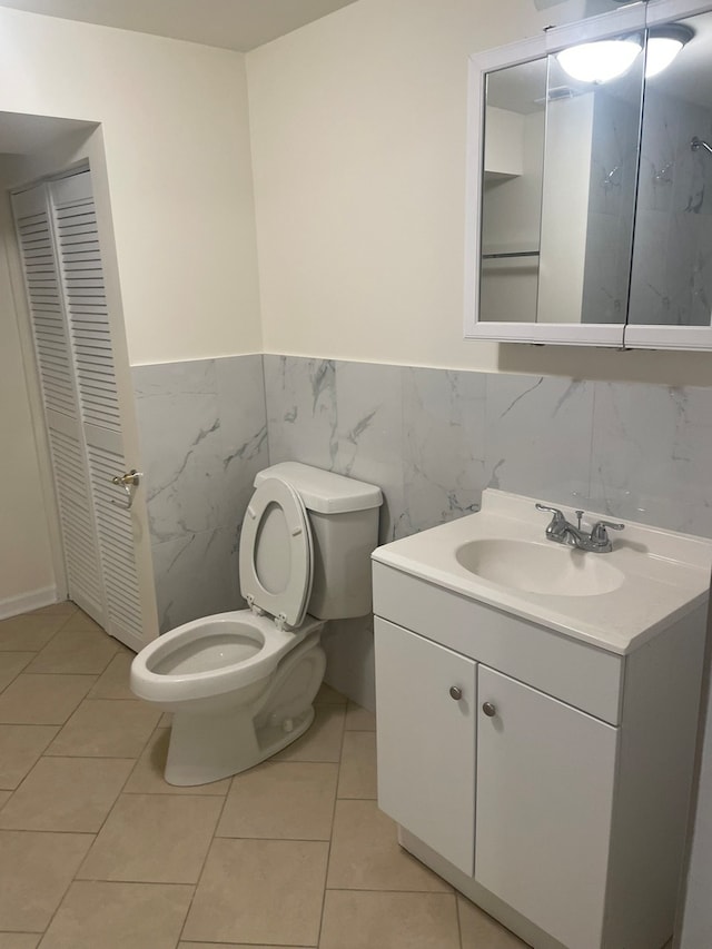 bathroom featuring tile walls, tile patterned flooring, vanity, and toilet