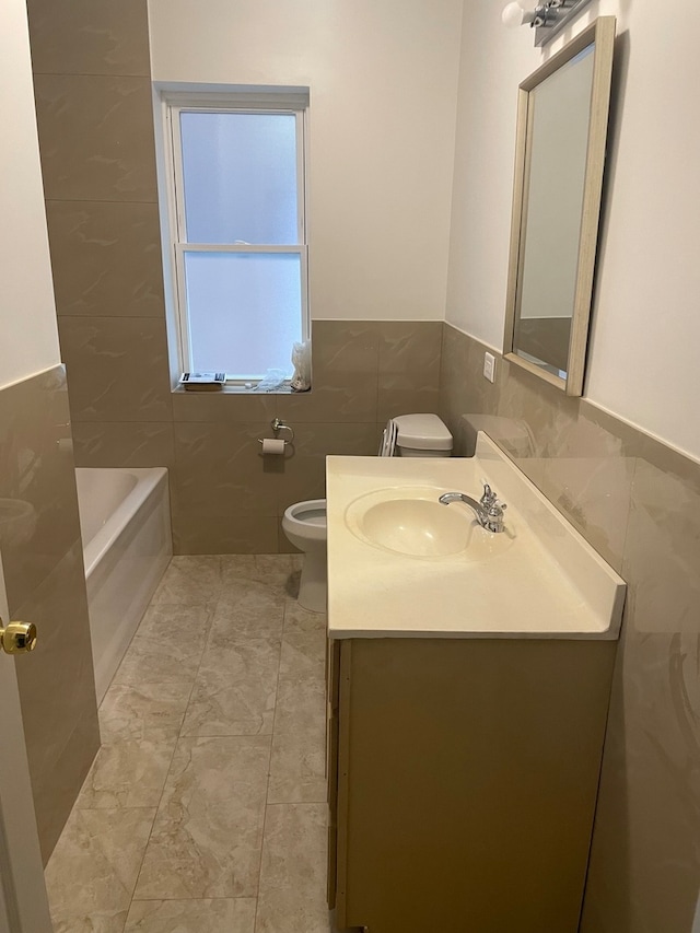 bathroom featuring a tub to relax in, tile walls, vanity, and toilet