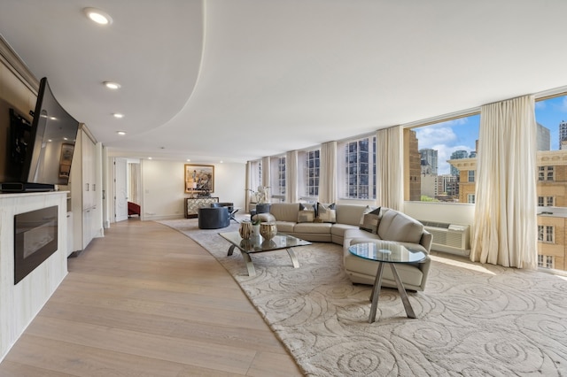 living room with a wall of windows and light hardwood / wood-style floors