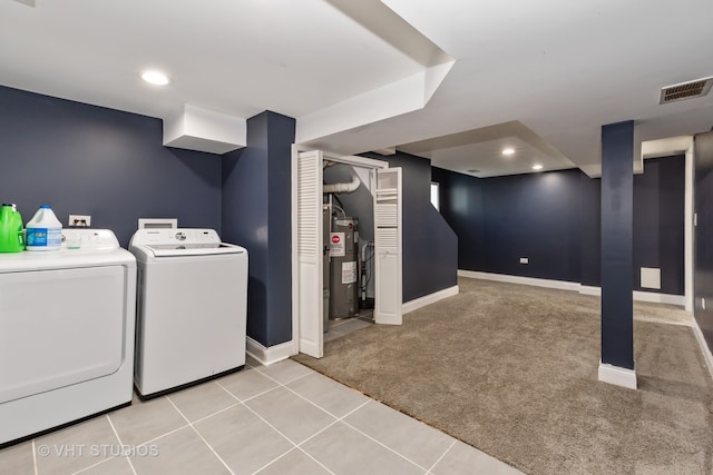 clothes washing area featuring carpet flooring, electric water heater, and washing machine and dryer