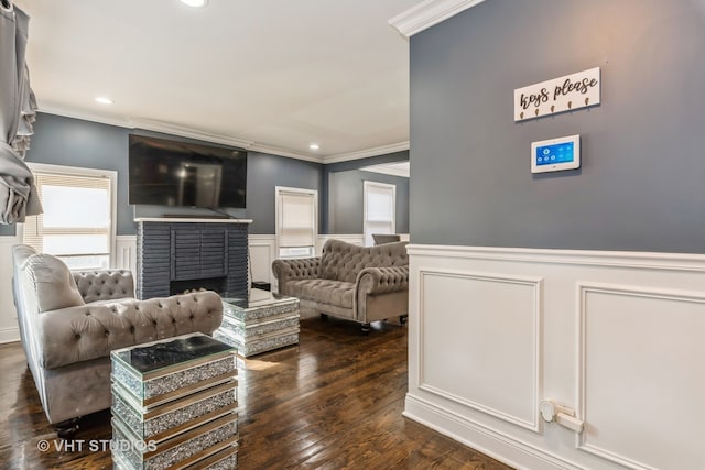 living room featuring a brick fireplace, dark hardwood / wood-style flooring, and ornamental molding