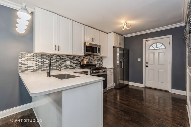 kitchen featuring stainless steel appliances, dark wood-type flooring, sink, white cabinets, and hanging light fixtures