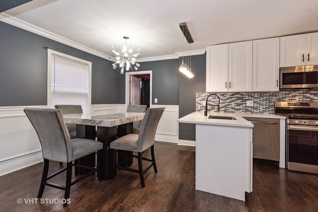 dining space with ornamental molding, an inviting chandelier, dark wood-type flooring, and sink